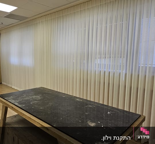 וילון לבן שקוף תלוי לאורך הקיר